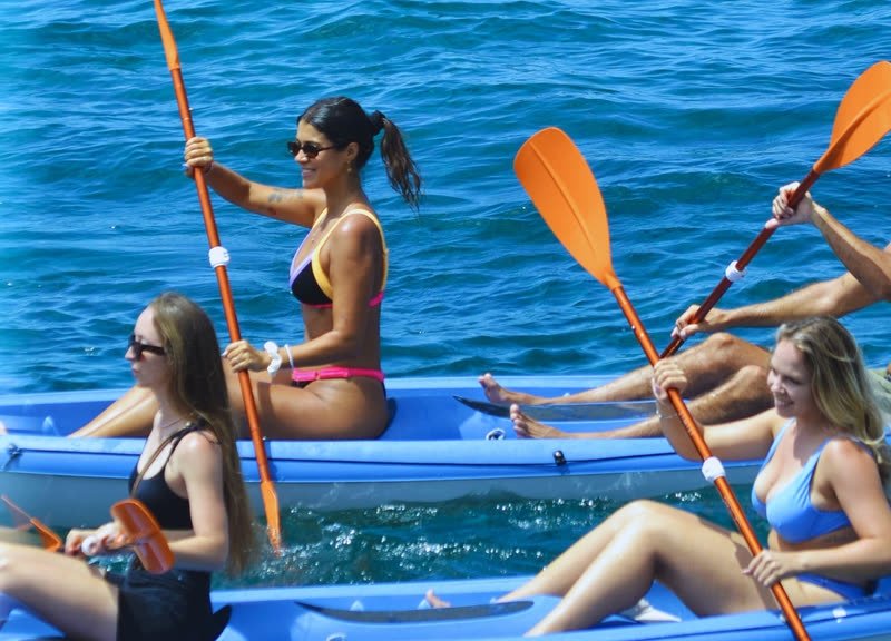 Dos chicas remando en kayak por el mar azul
