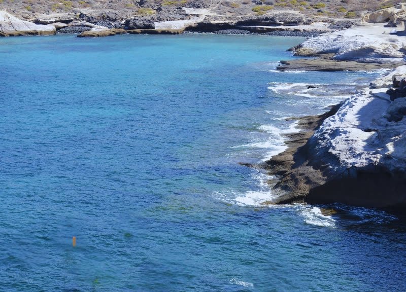 La costa de roca volcánica y agua turquesa