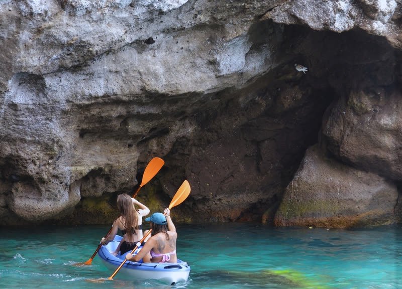 Dos chicas en kayak entrando en una cueva
